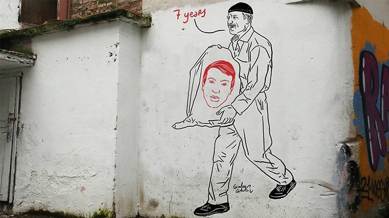 Karîkaturîstê Îtalî wêneyê radestkirina hestiyên ciwanê Kurd xêz kir