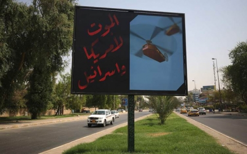 ملصقات في شوارع بغداد تدين أمريكا وإسرائيل جراء استهداف الحشد الشعبي