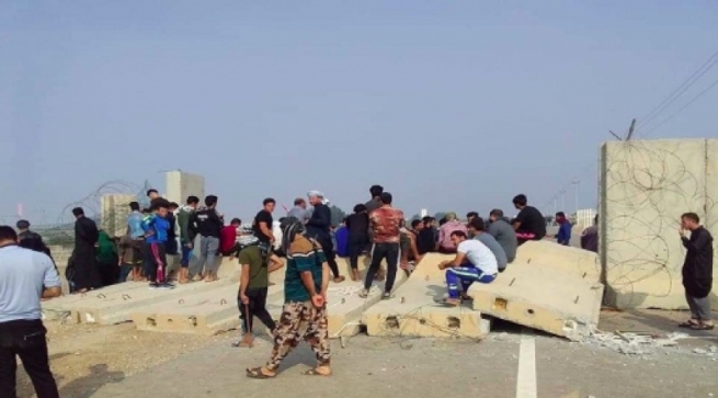  خۆپیشاندەرانی بەسرە دیوارە کۆنکرێتییەکانی کێڵگەیەکی نەوت دەڕووخێنن 