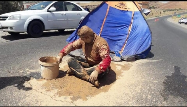 هونەرمەندێکی کورد قوڕ بەسەری خۆیدا دەکات